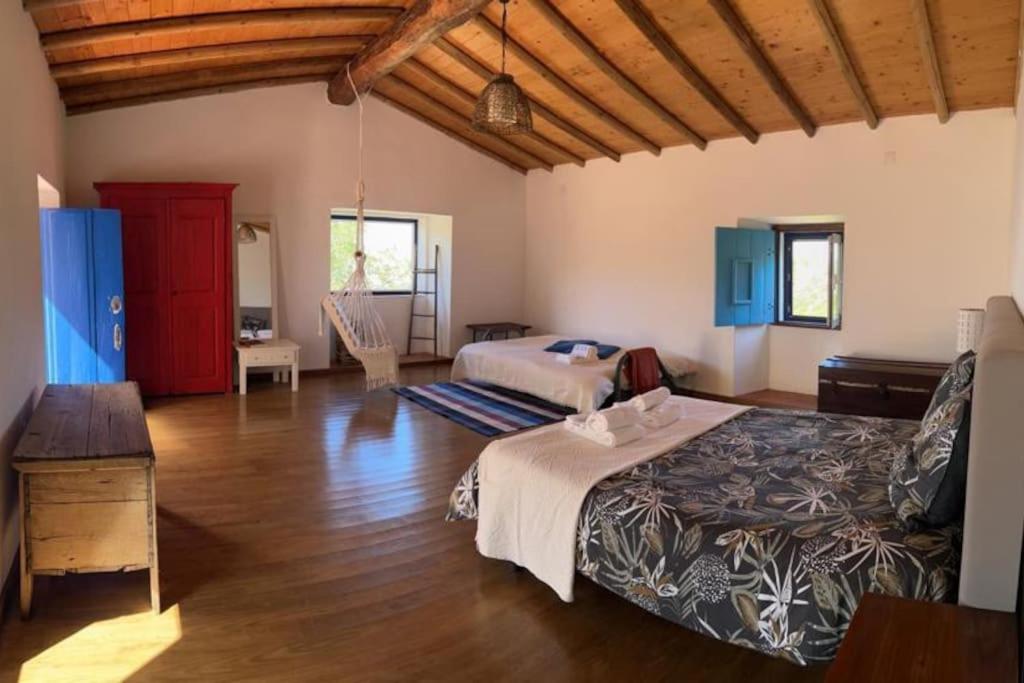 a bedroom with two beds in a room with wooden floors at Art-Marvão, Alojamento Rural in Marvão