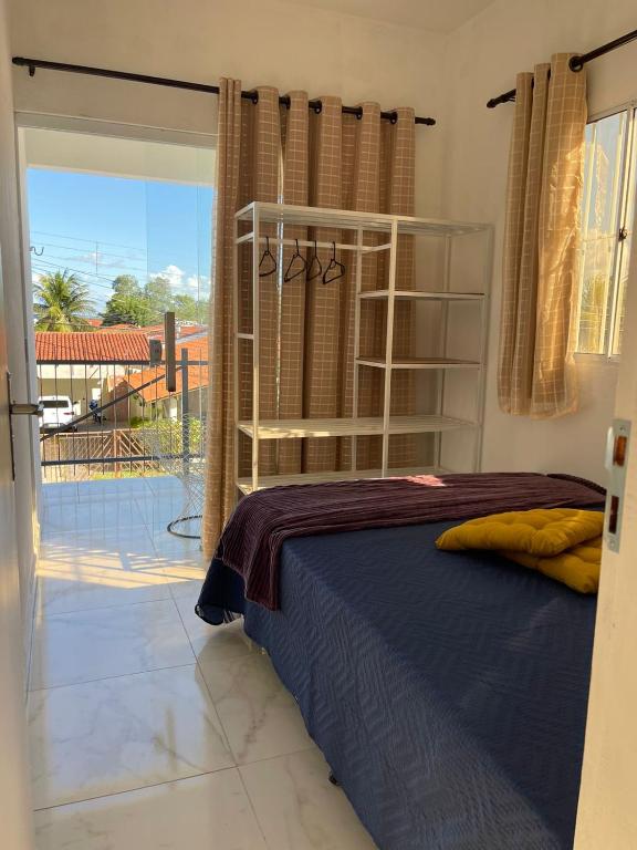 ein Schlafzimmer mit einem Bett in einem Zimmer mit einem Balkon in der Unterkunft Apartamento Novo em Piranhas in Piranhas