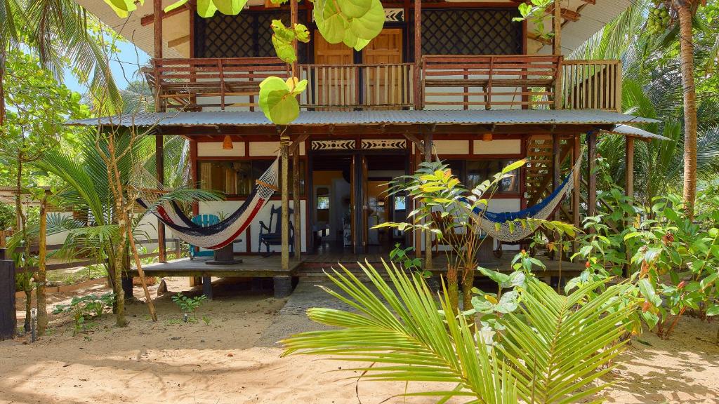 ein Gebäude mit einem Balkon mit Hängematte in der Unterkunft Arrecife Punta Uva - Hospedaje, bar y restaurante - Frente al mar in Punta Uva