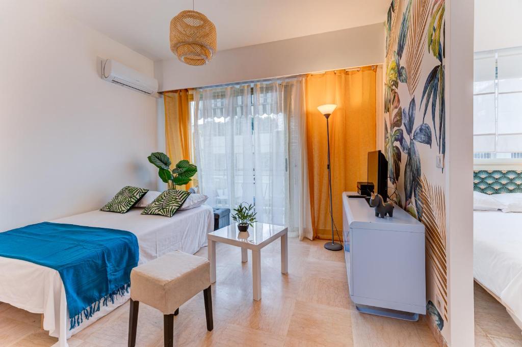 - une chambre avec un lit, une table et une télévision dans l'établissement Riviera Plage - Wifi, AC, 4 pers, à Nice
