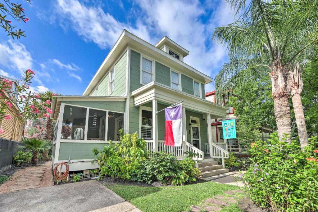 a green house with a palm tree in front of it at Historic Galveston Hideaway, Walk to the Beach! in Galveston