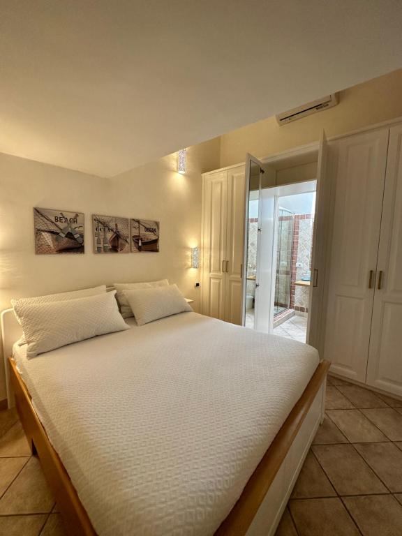 1 dormitorio con 1 cama grande con sábanas blancas en Sardegna Costa Corallina Appartamento Luxury Vista Mare in splendido villaggio - IUN R6511 en Costa Corallina