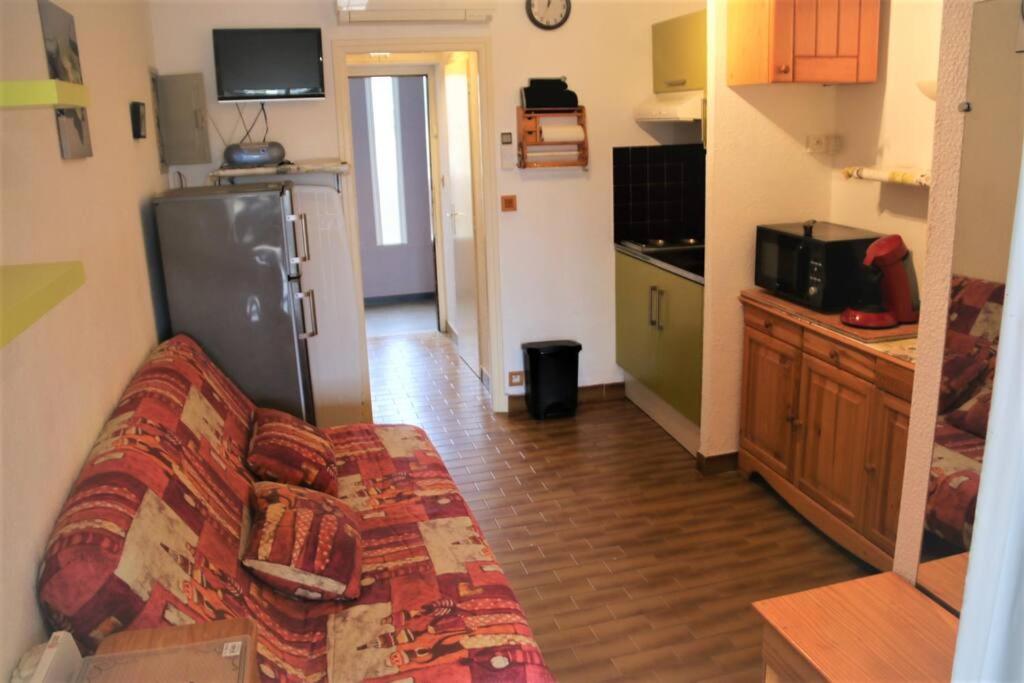 un salon avec un canapé et une cuisine dans l'établissement Studio 19, Héliopolis FGH au Village naturiste, au Cap d'Agde