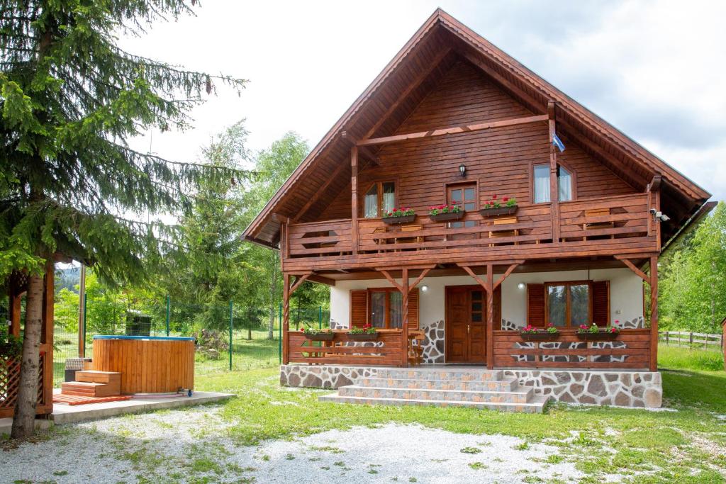 una casa de madera con techo de gambrel en Kamilla Vendégház Borzont, en Borzont