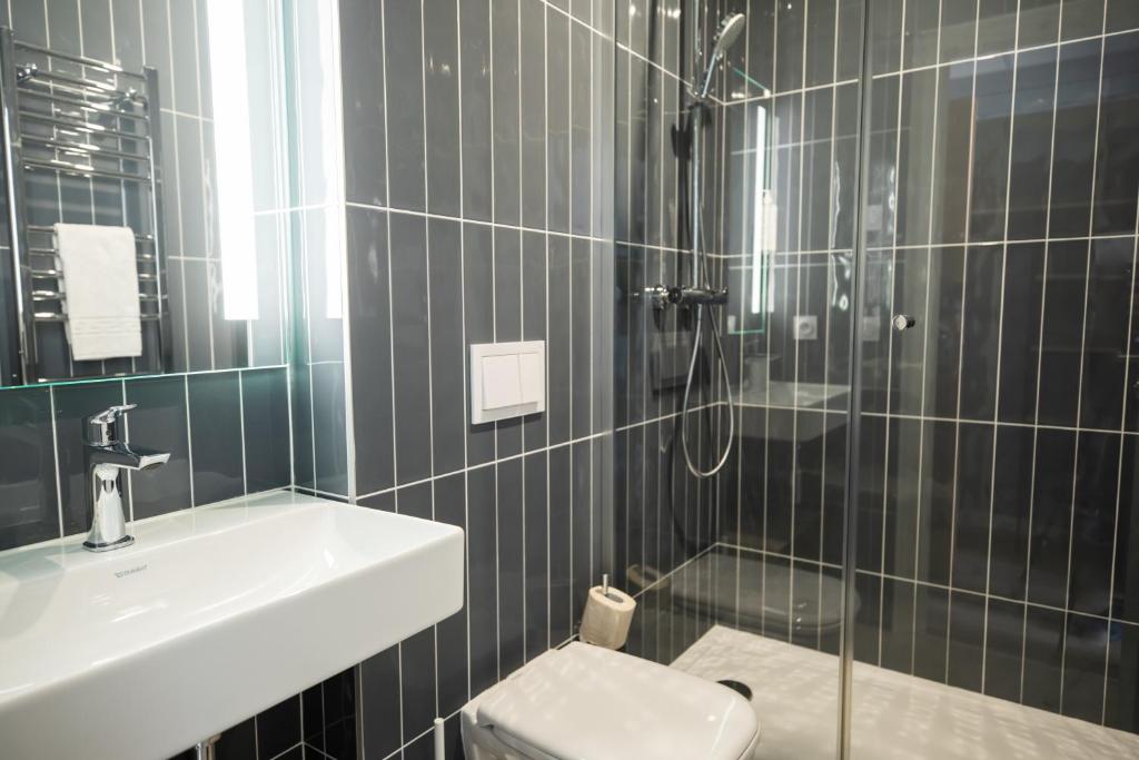 a bathroom with a toilet and a sink and a shower at Hôtel de la Baie in Crozon