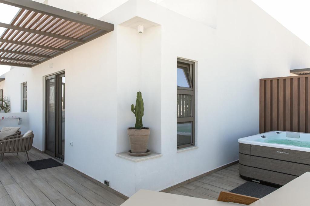 a bathroom with a tub and a cactus on the wall at Agrelli Hotel & Suites in Kardamaina