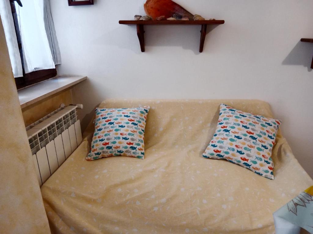 - deux oreillers installés sur un canapé dans l'établissement Casa girasole, à Isola del Giglio