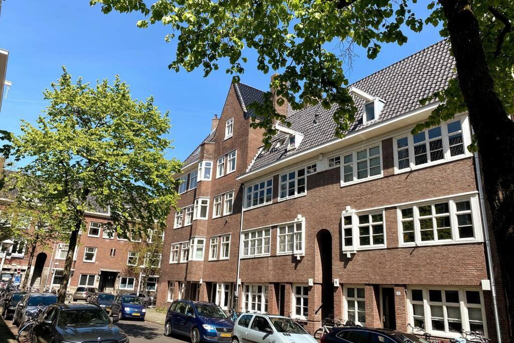een groot bakstenen gebouw met auto's geparkeerd voor het bij Boutique Studio Amsterdam near RAI and De Pijp in Amsterdam