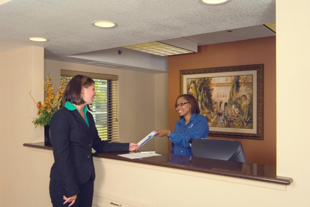 Dos mujeres están de pie en una recepción en Candlewood Suites Indianapolis Downtown Medical District, an IHG Hotel en Indianápolis