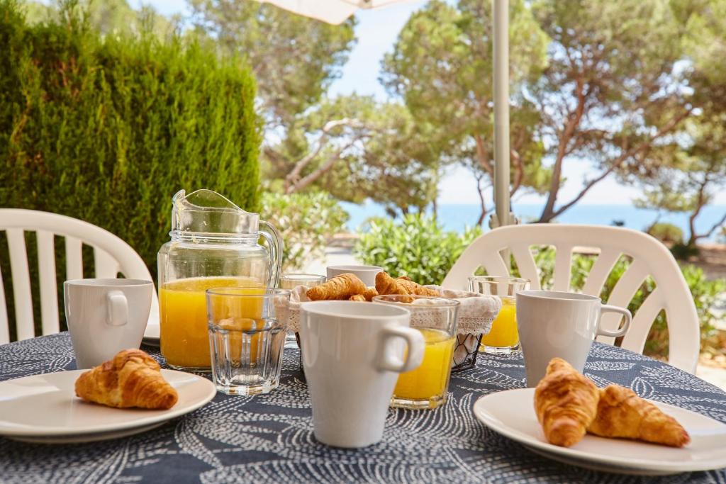 - une table avec des assiettes de croissants et de jus d'orange dans l'établissement La mejor vista al mar !!!, à Calafat