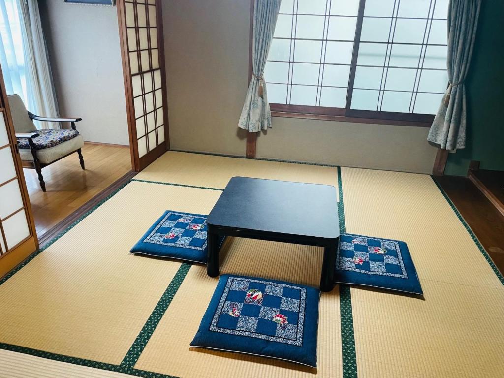 um quarto com uma mesa e dois tapetes no chão em My Summer Vacations - Vacation STAY 14738 em Kurashiki