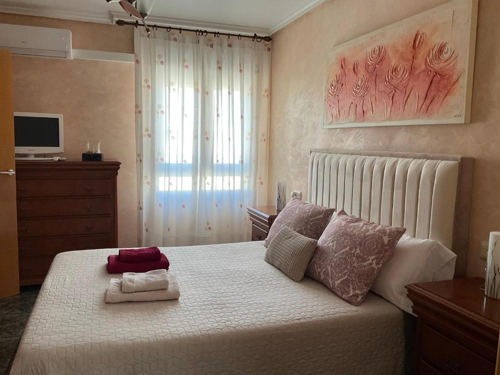 a bedroom with a bed with two towels on it at BRISA DE PONIENTE con cochera y aire acondicionado in Águilas