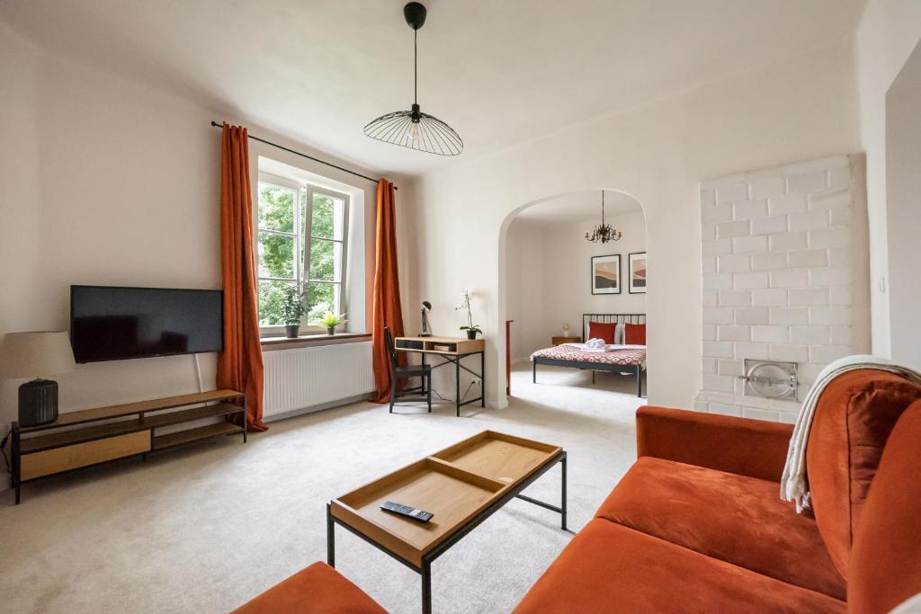een woonkamer met een bank en een tv bij Park Promenada Brown Apartment in Warschau