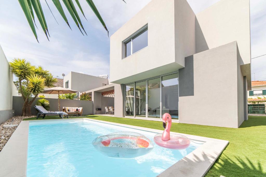 ein Haus mit einem Pool mit einem rosa Flamingo in der Unterkunft Villa Kamila in Aroeira