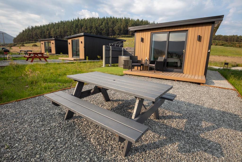a picnic table in front of a tiny house at OAKWOOD GLAMPING Mourne Mountains in Moyad