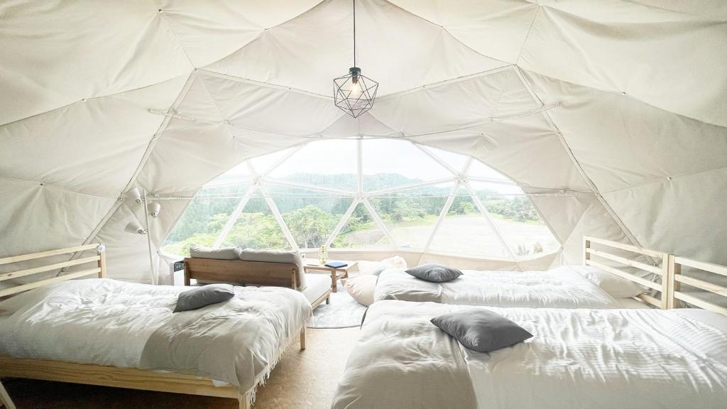 une chambre avec 3 lits dans une tente dans l'établissement amazing view room 2 - Vacation STAY 66302v, à Kushima