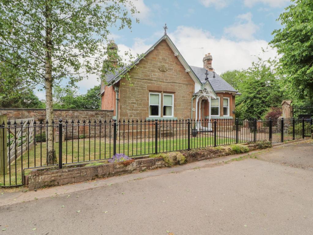 a fence in front of a house at North Lodge in Annan