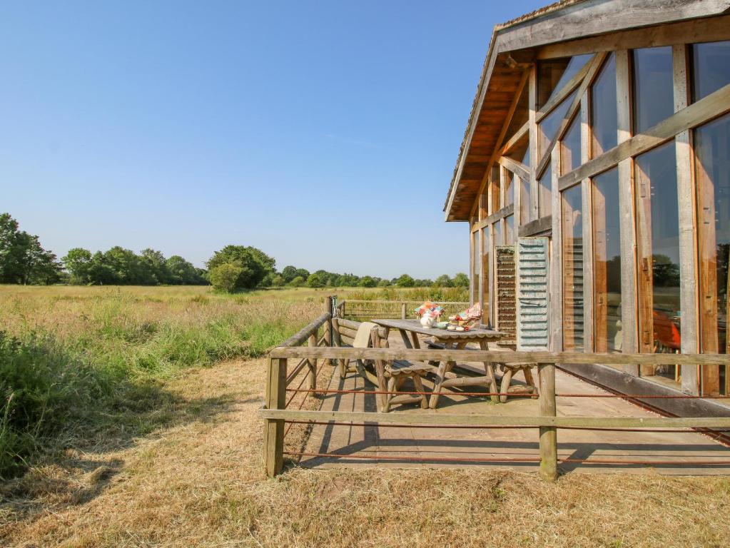 una casa con una mesa de picnic fuera de ella en The Tractor Shed, en Preesgreen