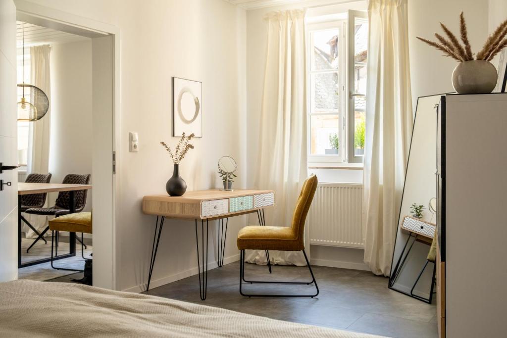 a bedroom with a desk and a chair in front of a window at Stilvolles Apartment in Bayreuther Fußgängerzone in Bayreuth