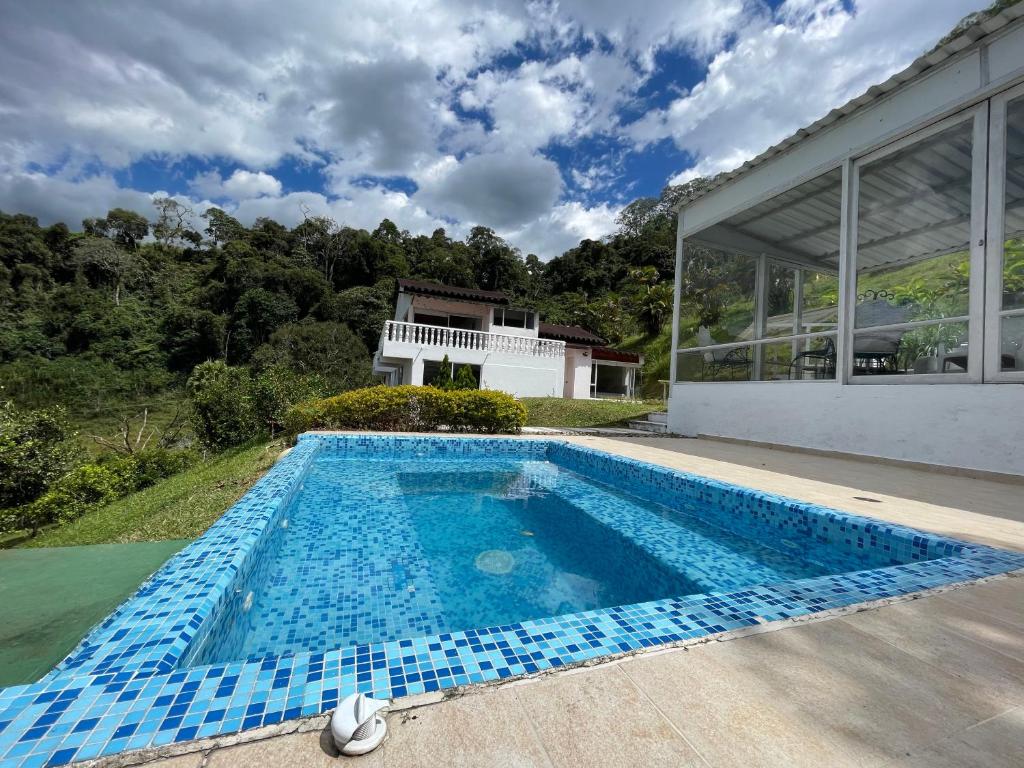 an empty swimming pool in front of a house at La Casa de la Montaña in La Vega