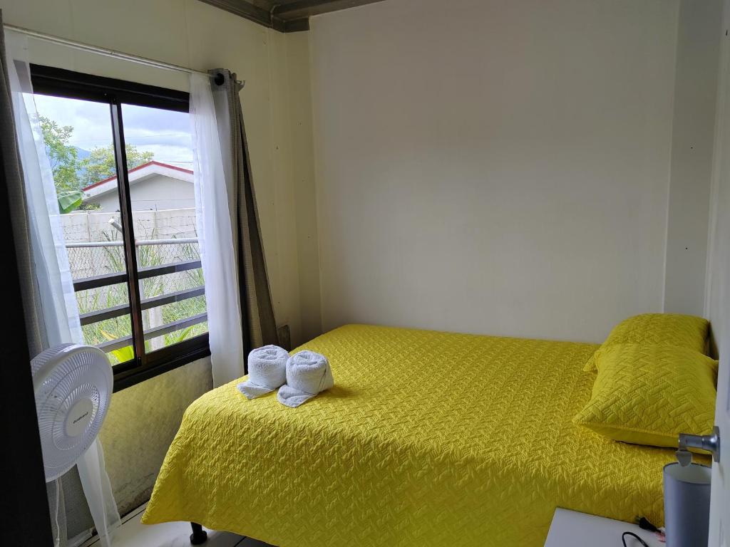 sypialnia z żółtym łóżkiem i oknem w obiekcie Hospedaje Eli 09 w mieście Pavones