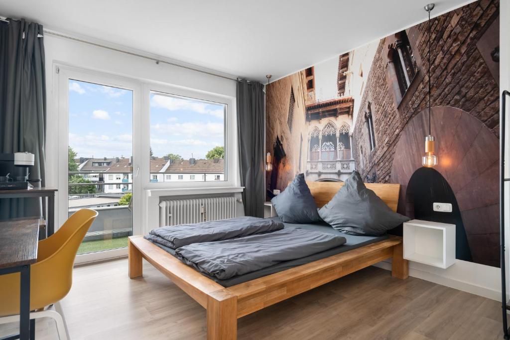 ein Schlafzimmer mit einem Bett und einem großen Fenster in der Unterkunft Apartment 5, direkt am Bahnhof in Aachen