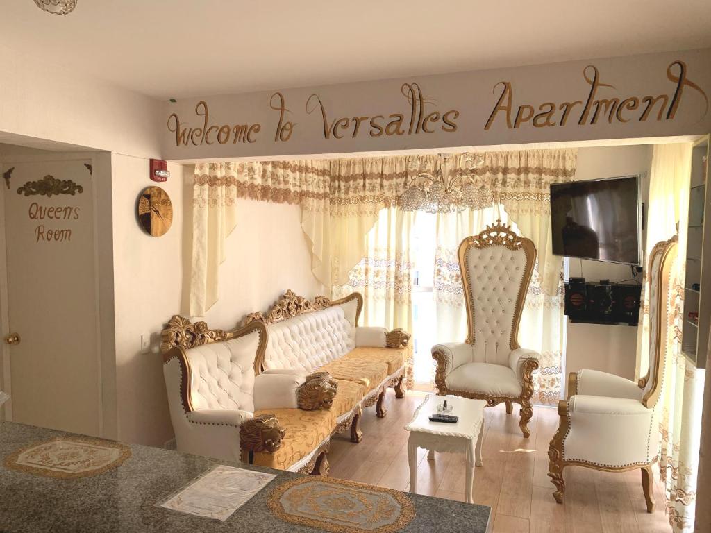 een woonkamer met een bank en 2 stoelen bij VERSALLES APARTMENT in Lima