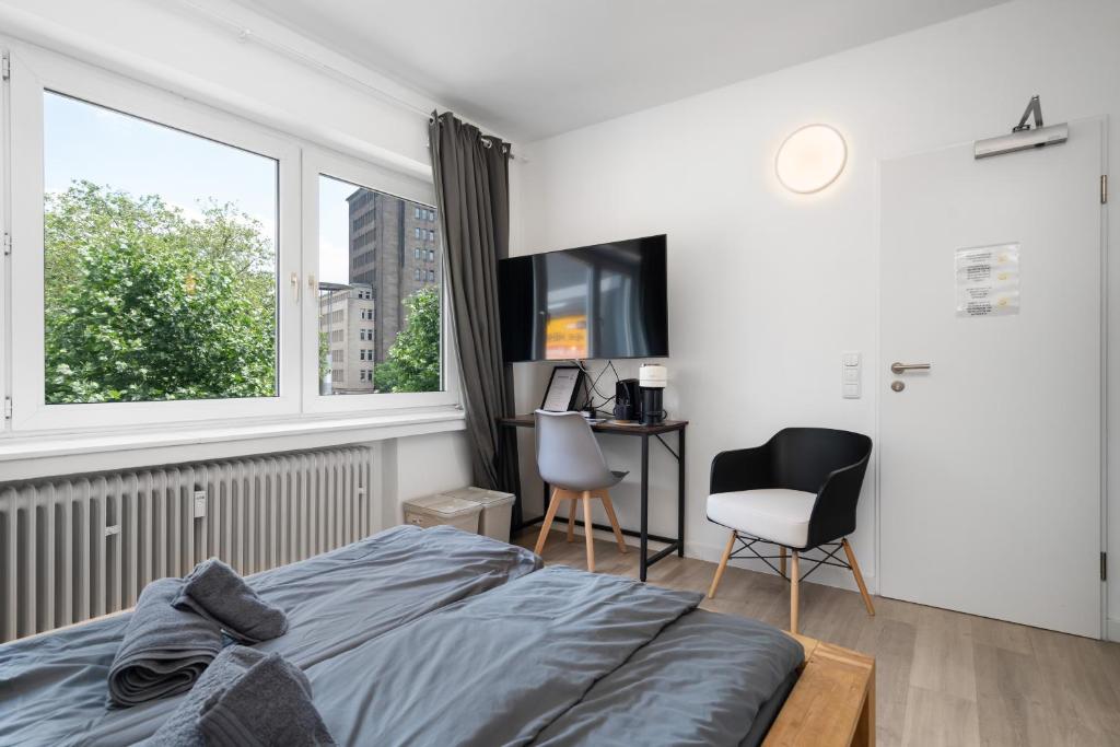 1 dormitorio con cama, ventana y escritorio en Apartment 6, direkt am Bahnhof en Aquisgrán