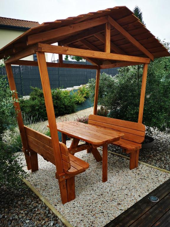 a wooden picnic table and bench with a gazebo at "Notre Bastide" Maison et table d'hôtes traditionnelle et végétarienne, Piscine, jacuzzi, Clim, , à 5 mn de SARLAT in Marcillac-Saint-Quentin