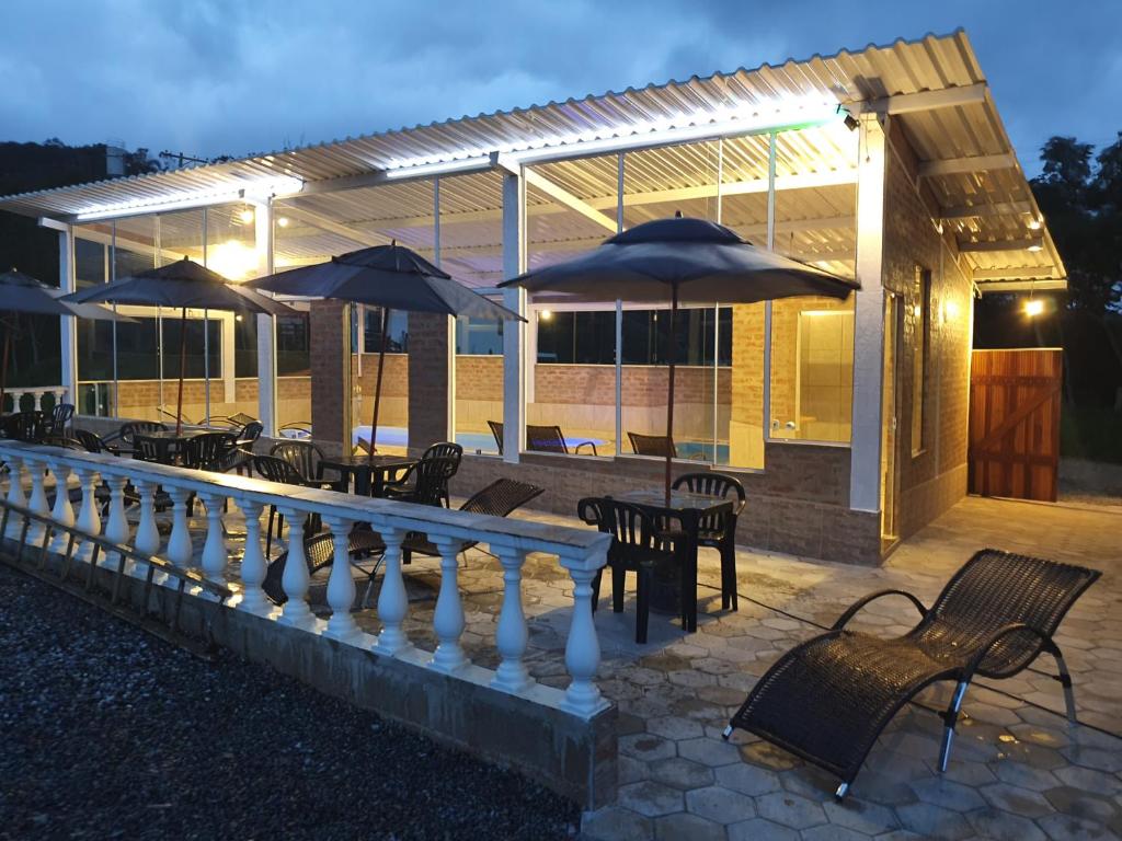 a group of tables and chairs with umbrellas in front of a building at Pousada Chalés São Francisco in Santo Antônio do Pinhal