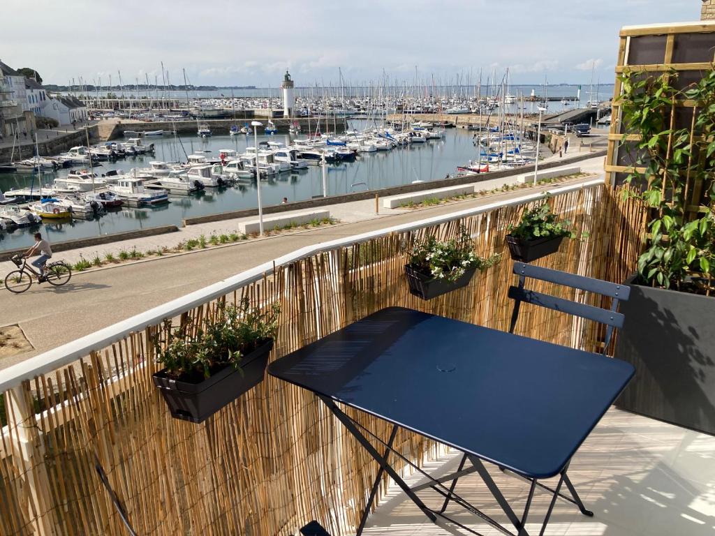 a blue table on a balcony with a marina at Studio du vieux port in Quiberon