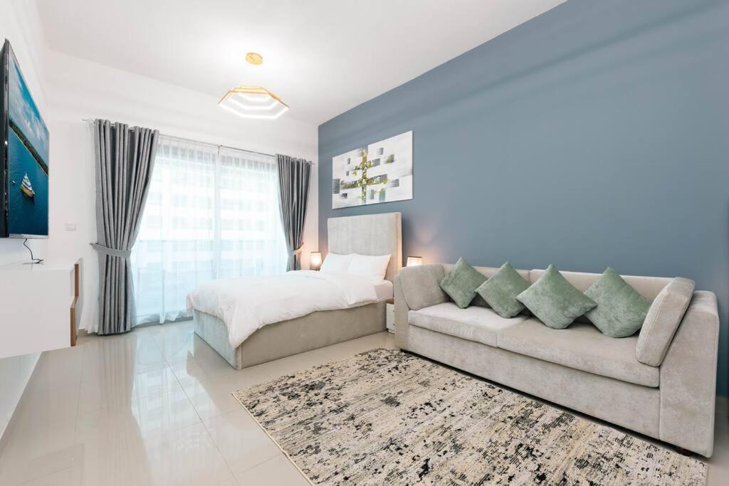 uma sala de estar com um sofá e uma cama em Urban Caves - Stylish Condo Near Marina Walk With City Views em Dubai