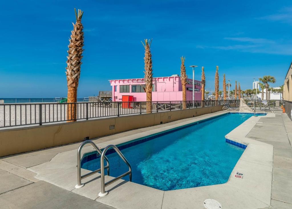ガルフ・ショアーズにあるPhoenix All Suites Hotelのヤシの木とビーチのあるスイミングプール