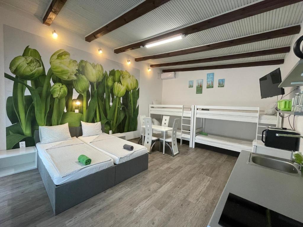a bedroom with a bed and a mural of plants at Tutti Apartman in Balatonlelle