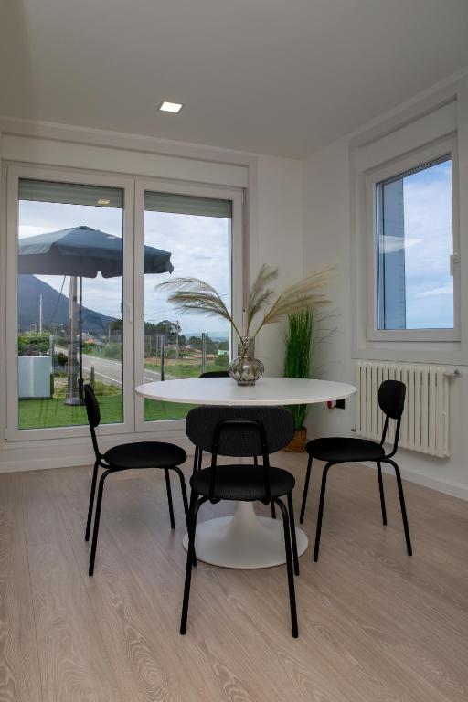 a dining room with a table and chairs and a window at HOGAR DEL MAR in Oia