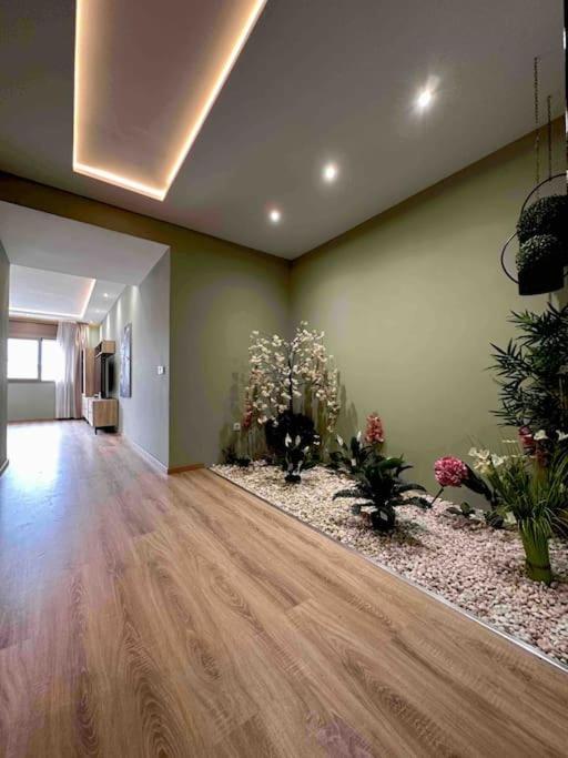 una sala de estar con suelo de madera y flores en Le Tropical, en Tánger