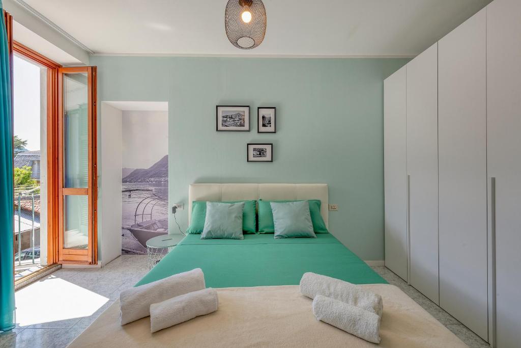a bedroom with a green bed with two chairs at La Casa del Pescatore in Cernobbio