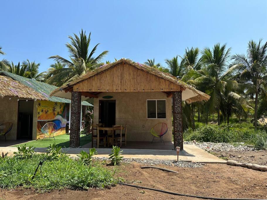 a small house with a table and chairs outside at Casa Aurora Playa La Saladita in La Majahua