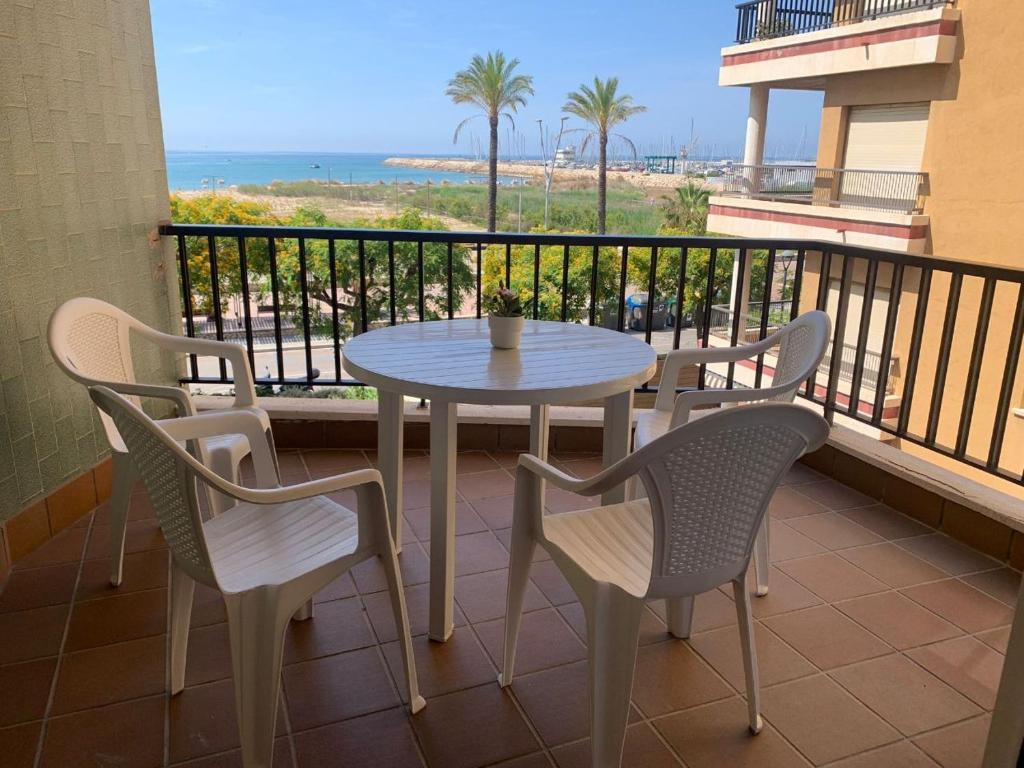 una mesa y sillas en un balcón con vistas a la playa en Apartamento Primera Línea de Playa Port-Segur, en Segur de Calafell