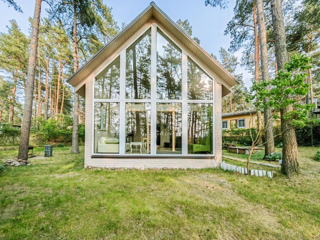 una casa con una gran ventana en un patio en River bank vacation home, en Jūrmala