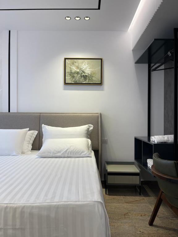 Olivea Apartments في فيليبوجي: غرفة نوم بسرير ابيض ومكتب