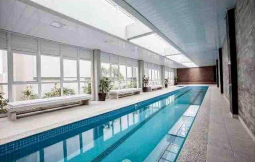 una gran piscina en un edificio con ventanas en Studio flat Mid Home, en Curitiba