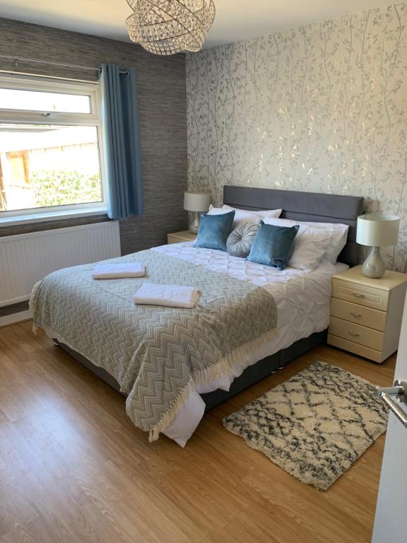 a bedroom with a large bed with blue pillows at Hafan Traeth in Prestatyn