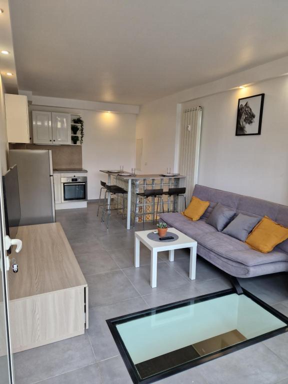 un salon avec un canapé et une table dans l'établissement Souplex avec place de parking, à Antibes