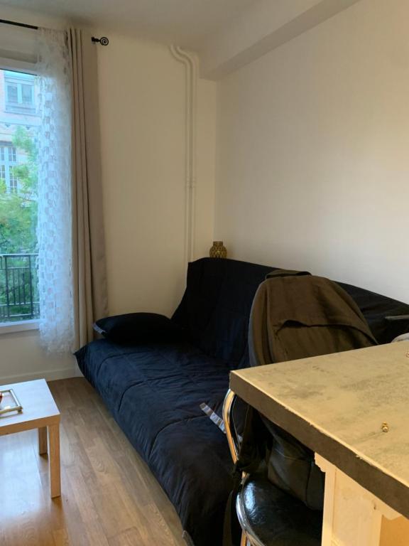 a living room with a couch and a table at Studio renovated in the heart of Paris in Paris