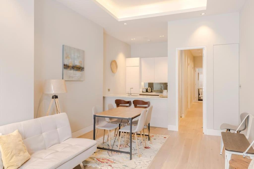 un soggiorno con divano bianco e tavolo di Central Holborn Bloomsbury flats a Londra