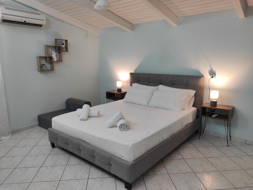 Paxos Dream House في Vlachopoulátika: غرفة نوم عليها سرير وفوط