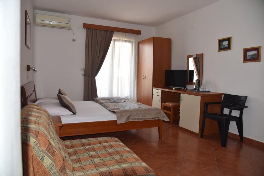 um quarto com uma cama, uma secretária e uma cadeira em Guest House Zec em Budva