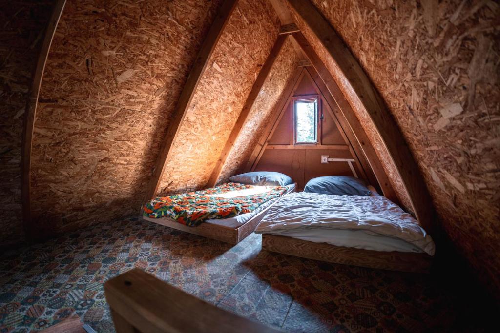 twee bedden in een kleine kamer in een grot bij Kemp Sluníčko in Doksy