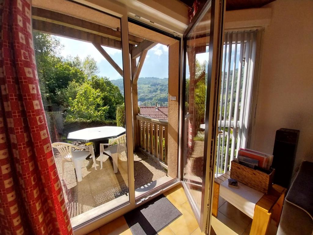 een kamer met een balkon met een tafel en uitzicht bij Hameau des chaumes vue panoramique in La Bresse